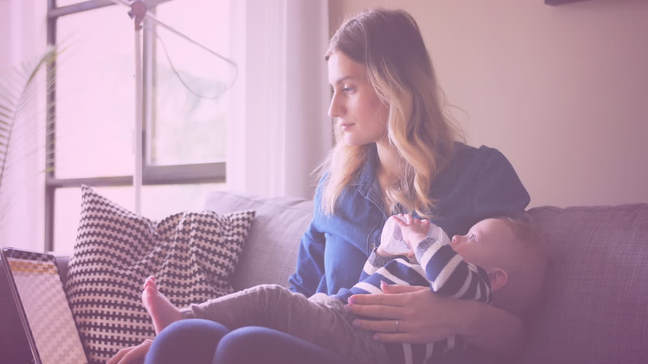 animación de iconos de corazón sobre una madre caucásica sosteniendo a su bebé