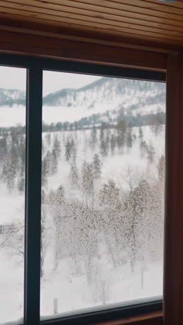 scenic winter landscape seen from big panoramic window of hotel room. giant forestry mountains covered with white snow in gorny altai region closeup