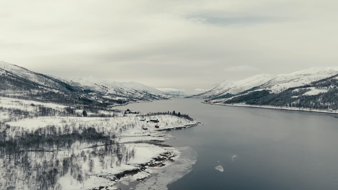 Schneebedeckte Berge und Küstendorf im Winter bei Svolvær, Norwegen. Drohnenaufnahme.