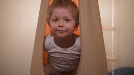 adorable boy in white t-shirt smiles looking in camera