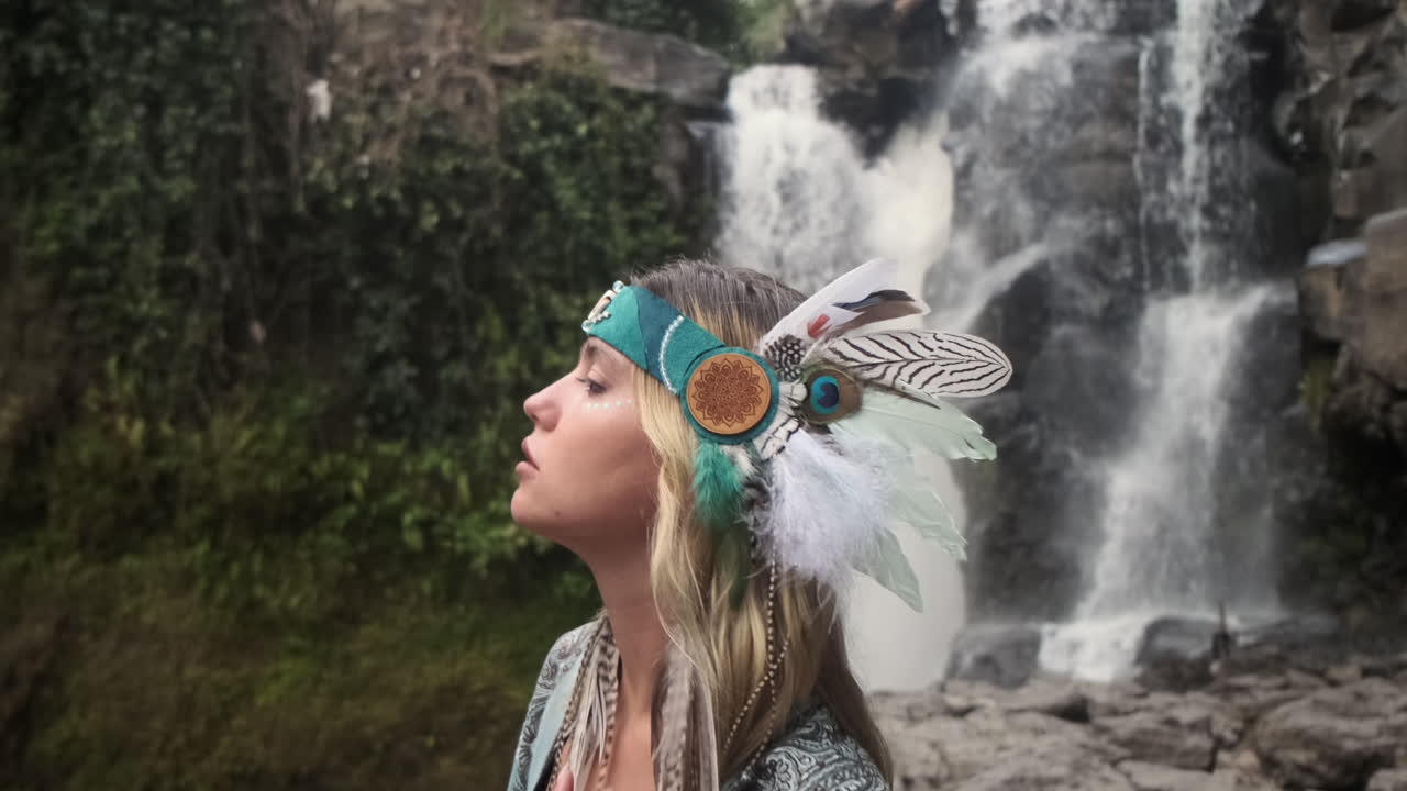 mujer con cinta de plumas en la cascada