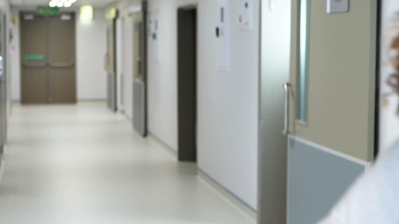 médico interactuando con mujer embarazada en el pasillo