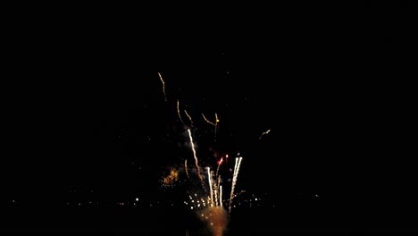 una vista de avión no tripulado de fuegos artificiales del 4 de julio, capturado a media velocidad, con múltiples explosiones en todos los colores en una noche de verano tranquila