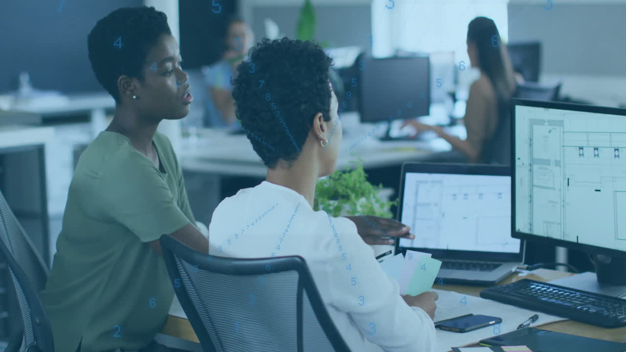 Two colleagues discussing project over digital data animation in modern office