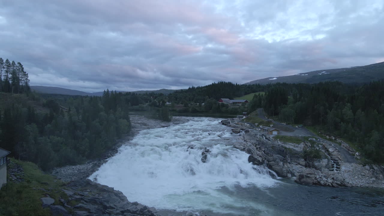 un río ancho y poderoso con una gran cascada, ubicado en el norte de noruega