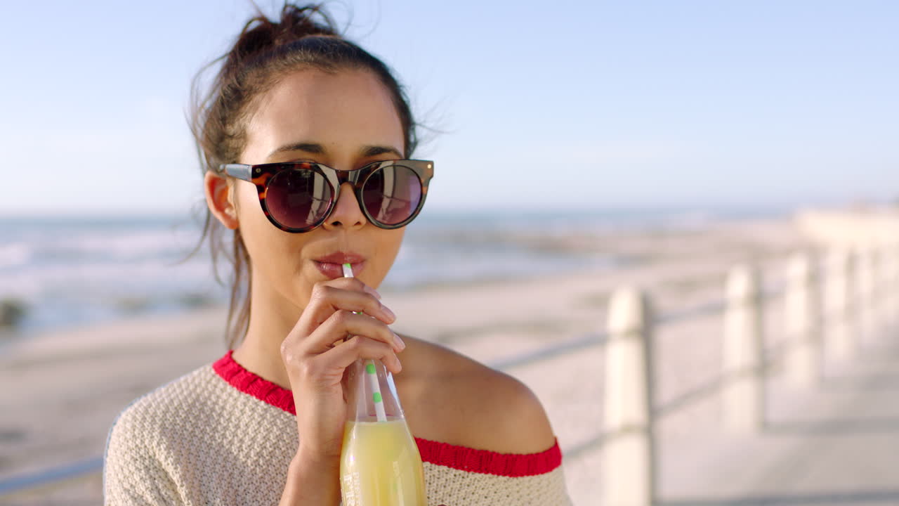 Woman drinking a healthy juice on a beach day