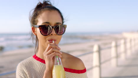 mujer bebiendo un jugo saludable en un día de playa