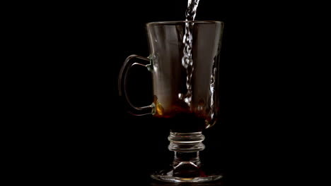 hot water pouring over coffee granules in a glass