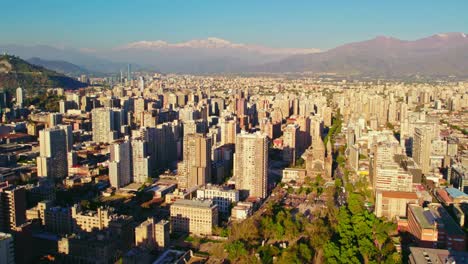 Vista-Aérea-Panorámica-Sobre-El-Parque-Almagro-Hacia-El-Centro-De-Santiago,-El-Horizonte-Urbano-Moderno-De-La-Ciudad-Y-Las-Montañas.