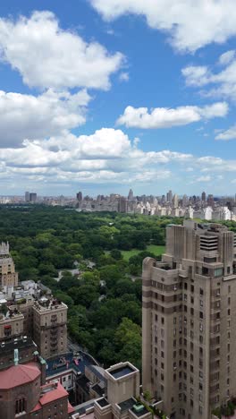 vertical pan vertical drone shot of central park with upper west side buildings in the foreground, offering a dynamic aerial view of nyc's iconic skyline and green space