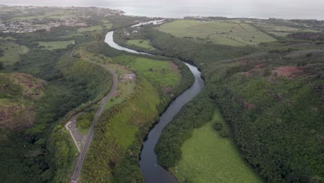 dramatic aerial footage of famous wailua river with pacific ocean coastline and a driveway jungle landscape kauai hawaii with waterfalls and scenic natural wonders