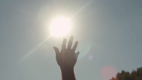 hand reaching towards the sun