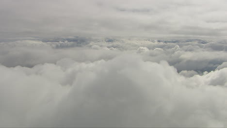 helicopter shot flying over the afternoon clouds that are white and fluffy