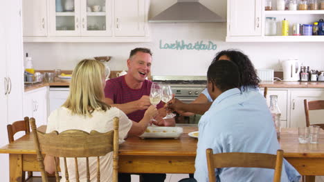 mature couple entertaining friends at dinner party