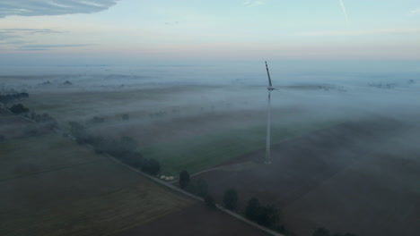 mysterious aerial shot of windmill on agriculture field with mystic fog,europe