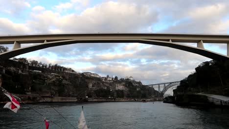 rabelo boat sails under ponte infante dom henrique in porto, portugal