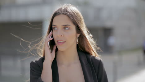 chica sorprendida hablando por teléfono celular al aire libre