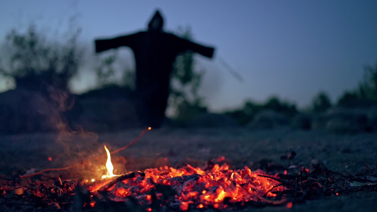 Fairy tales on Halloween. Landscape night forest view with witch standing near bonfire