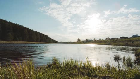 river and village landscape under a sunny sky