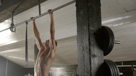man doing pull ups in gym