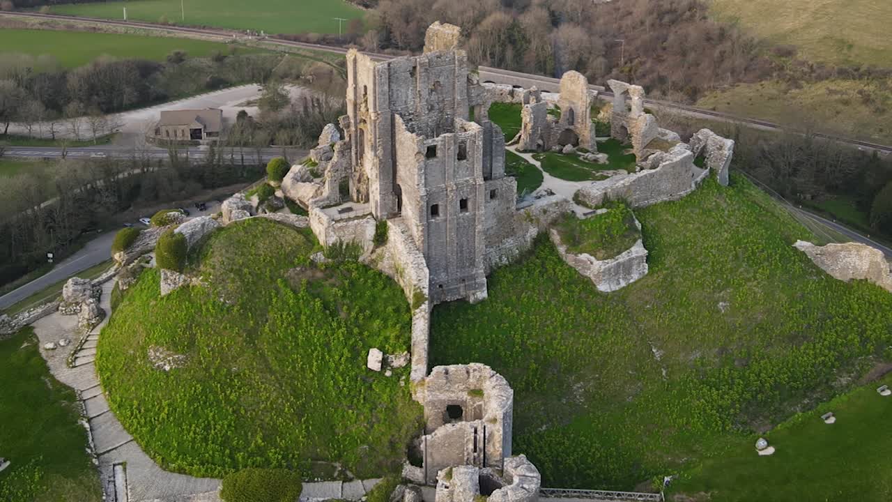 Contrasto cromatico tra la collina verde e le rovine del castello di Corfe nella contea di Dorset, Inghilterra.