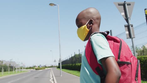 niño con máscara en la cara cruzando la carretera