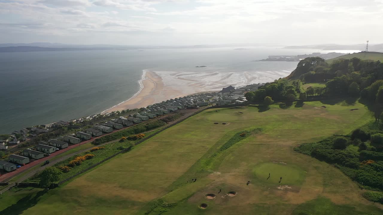 골프 코스에서 스코틀랜드의 4분의 1 해안선까지 패닝하는 공중 영상
