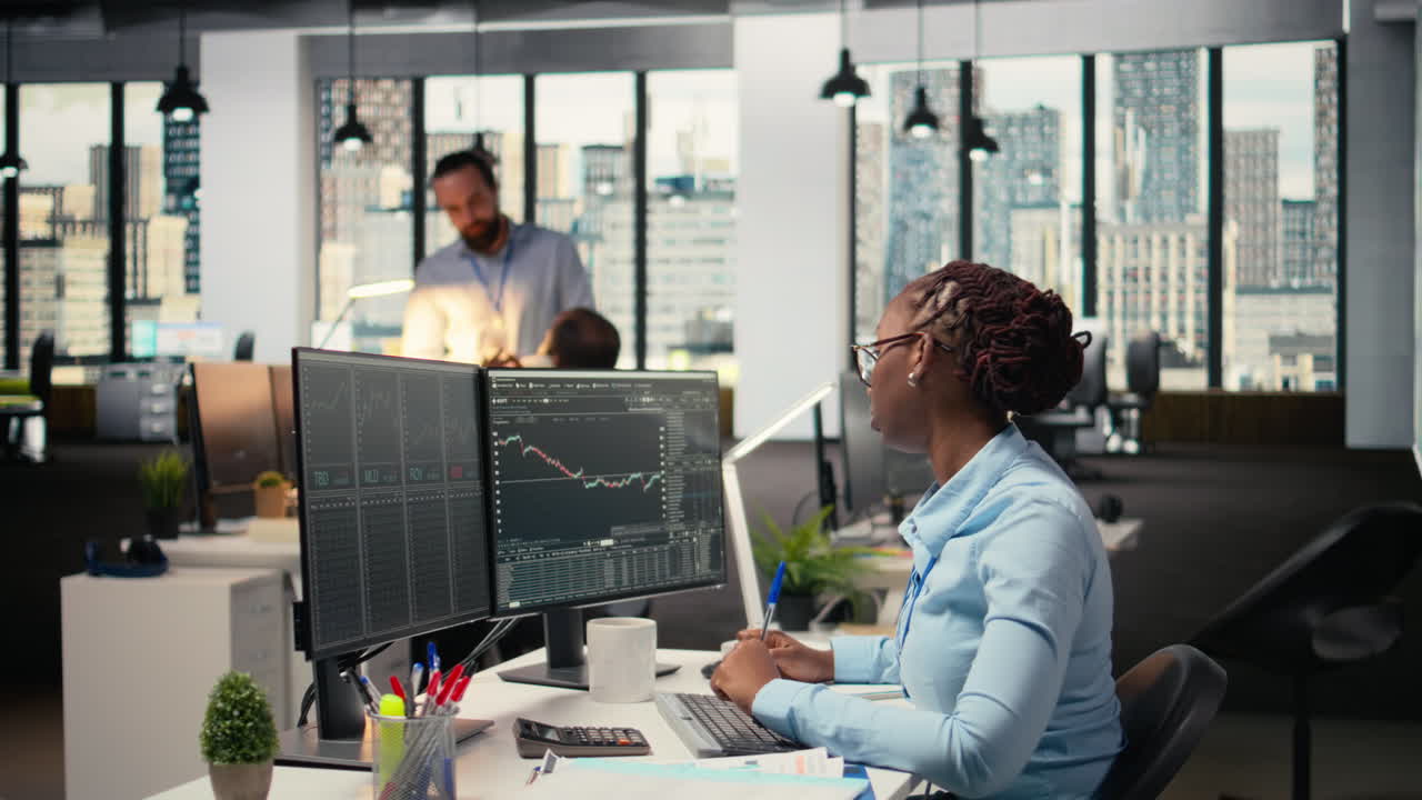 Day trader analyzes stock market price charts, taking notes