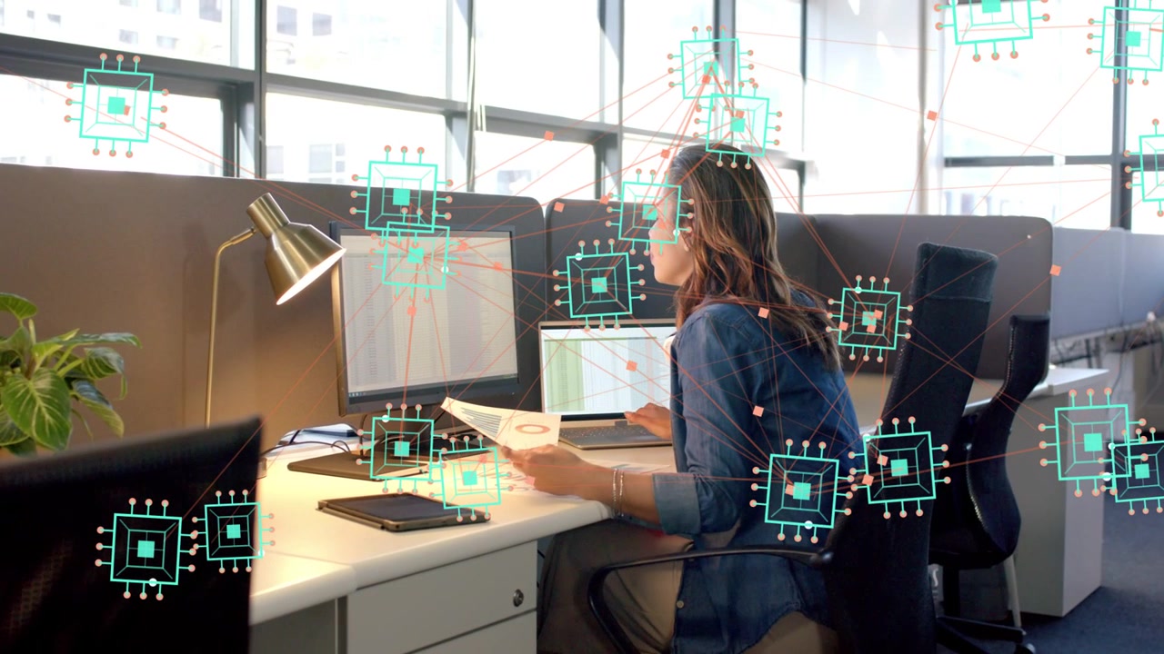 Office worker reviewing paper, verifying data on monitors while AI overlay following cursor