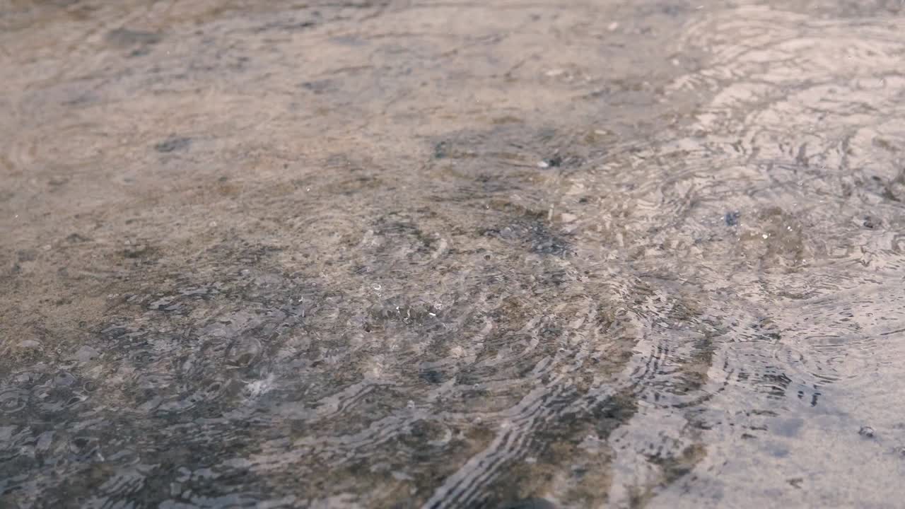 폭우가 내리는 동안 웅이에 떨어지는 몇 가지 방울의 4k 영상.