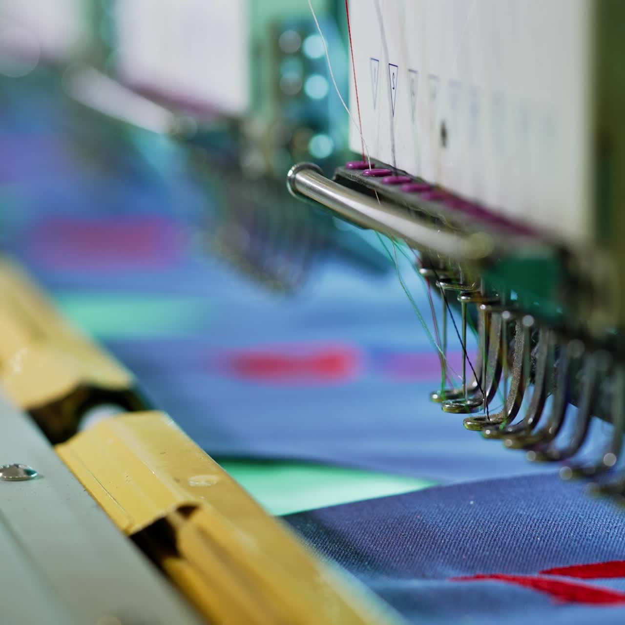 Needle of a sewing machine makes a thread stitches. Sewing needle of automatic sewing machine moving rapidly. Close-up