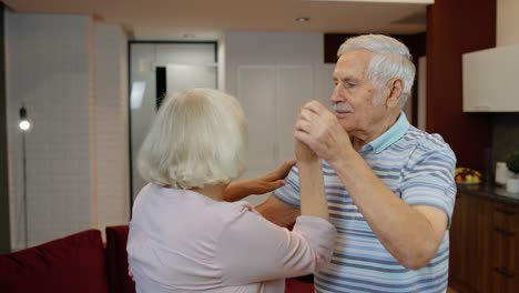 Felices-Abuelos-Mayores-Despreocupados-Y-Enamorados-Bailando-Vals-En-Una-Sala-De-Estar-Moderna-En-Casa