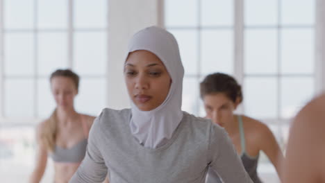 hermosa mujer musulmana practicando yoga pose de oración en el gimnasio disfrutando de un estilo de vida saludable y equilibrado usando pañuelo en la cabeza