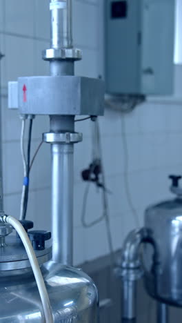 contemporary equipment on a milk farm indoors. stainless containers for keeping and processing dairy products on a milk factory.. vertical video