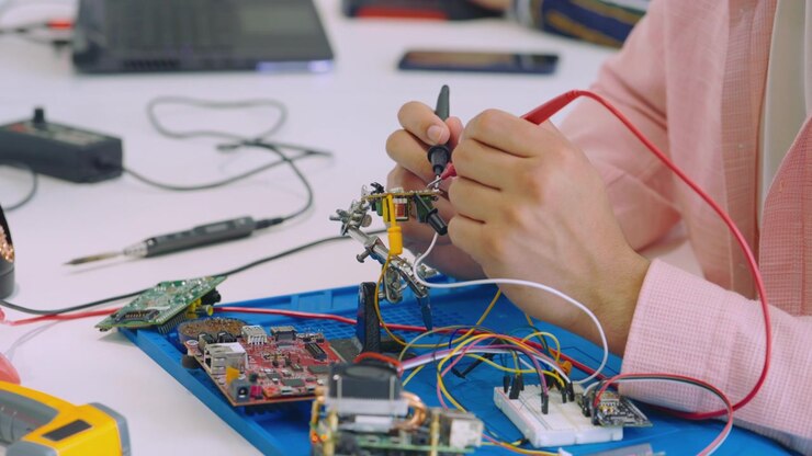 Ingegnere che testa un circuito elettronico con i puntali di un multimetro
