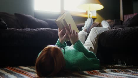 teenage girl reading a book on the floor