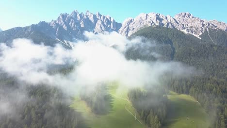 Drone-Sobre-Las-Nubes,-Hermosas-Cimas-De-Montañas-Con-Pista-De-Esquí-Verde-En-Verano,-Innichen,-Tirol