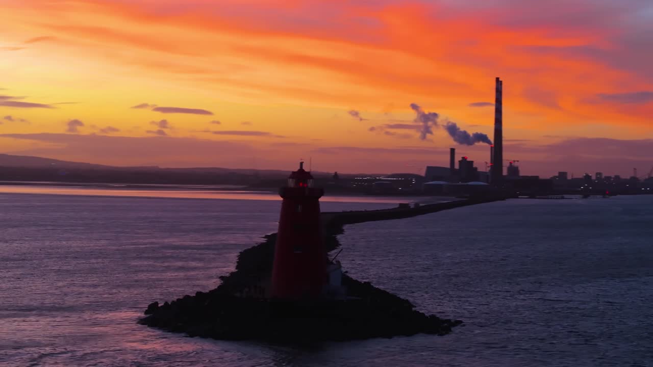 4K cinematic drönarfilmmaterial som fångar den ikoniska Poolbeg-fyren och Poolbeg-skorstenarna i Dublin under en hisnande solnedgång, badade i intensiva gyllene timmen-färger_56