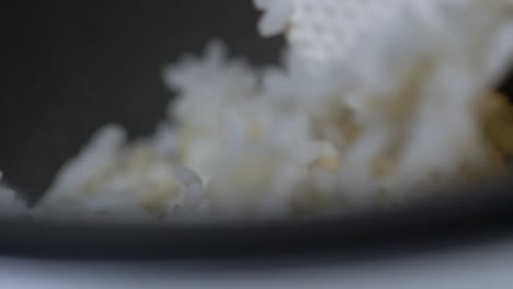Extreme-Close-Up-of-Spatula-Mixing-Rice,-Steam-rising