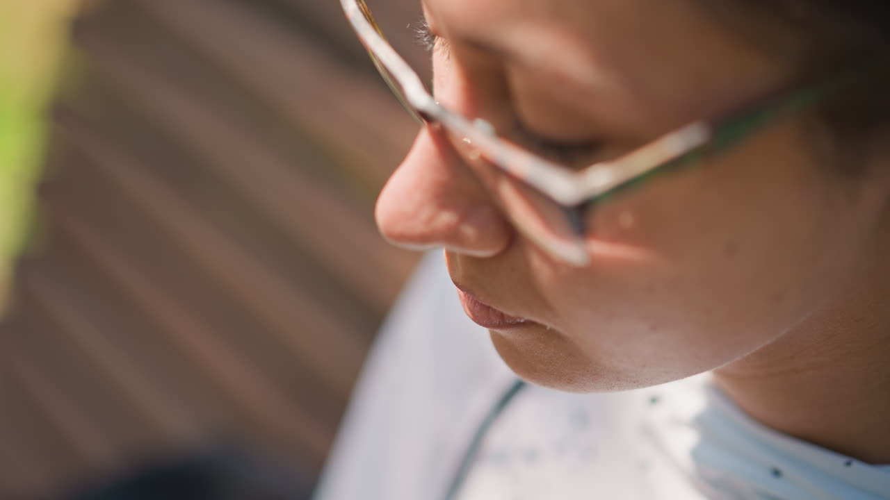 Woman eating healthy salad outside in sunlight, Relaxed woman eats crisp salad on park bench during midday, Outdoor setting with woman enjoying nutritious salad as sunlight filters through leaves