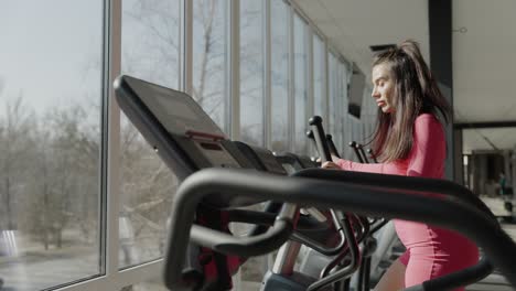 woman exercising on outdoor elliptical cross trainer machine in park fit woman using an elliptical cross trainer machine for a cardiovascular workout at a public park gym this outdoor exercise equipment helps improve stamina burn calories and tone the body