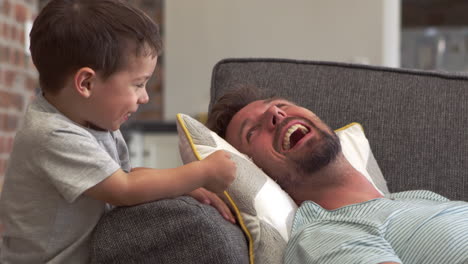 Padre-E-Hijo-Se-Divierten-Jugando-Juntos-En-El-Sofá