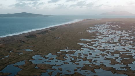 toma de dron de la playa de berneray y el machair a la hora dorada