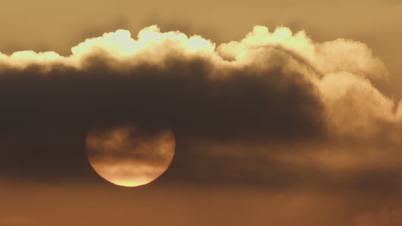 el sol oscurecido por las nubes al anochecer