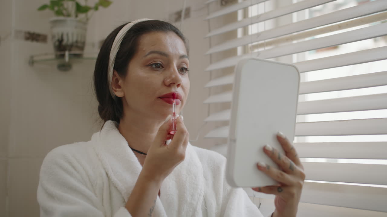 Brunette Using Red Liquid Lipstick before Going out