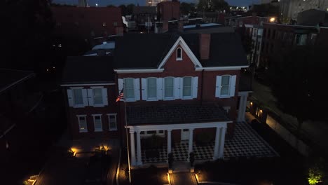 large house in usa city flying american flag at dusk