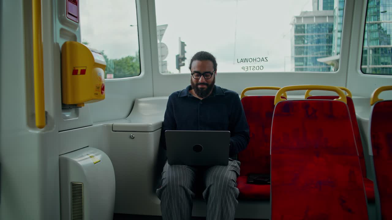 Man using laptop on a bus