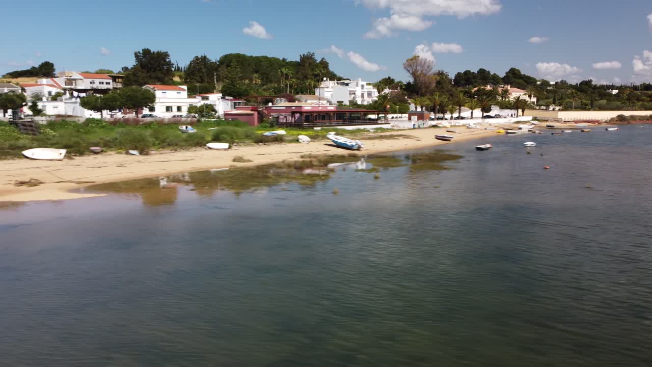 panorámica aérea de un pequeño y hermoso pueblo justo sobre una hermosa laguna en el algarve portugal