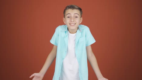 un niño aplaudiendo emocionado a la cámara.