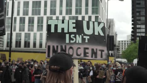 London Protestor Holds Up UK Isn't Innocent Sign BLM